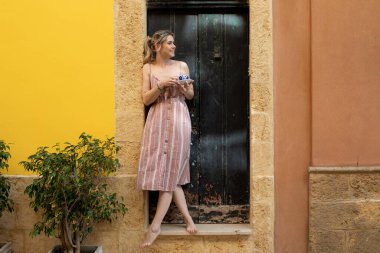 Sarışın, neşeli, at kuyruklu bir kadın. Bahçede ya da arka bahçede dinleniyor. Çay ya da kahve içmek, yabancı bir evde sakin bir atmosfer. Hafta sonu etkinliği