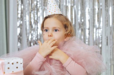 Zevk alıyorum. Parti şapkalı ve pembe elbiseli 4-5 yaşındaki güzel bir kız doğum günü pastasını tattıktan sonra parmaklarını zevkle yalıyor. Anlık zevkler. Mutlu bir çocukluk. Festivalsel etkinlikler. 