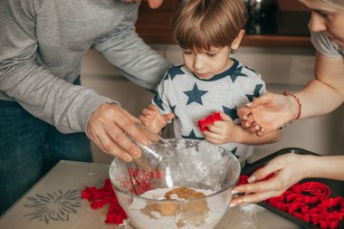 Küçük çocuk, 45 yaşında, hamur yoğurmaya tutkulu. Annem ve babam mutfakta ona yardım ediyor. Mutlu aile zamanları. Hobi olarak. Takım çalışması. Tüm aile. Baba, anne, oğul