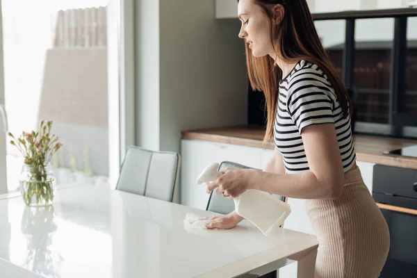 Genç Güzel Bir Kadının Mutfakta Dikilip Beyaz Masaya Vazo Serptiği — Stok fotoğraf