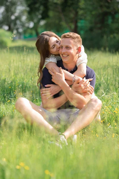 可爱的年轻夫妇坐在公园的草地上接吻 年轻男女享受夏日 恋爱中的快乐人 甜蜜的月亮 — 图库照片