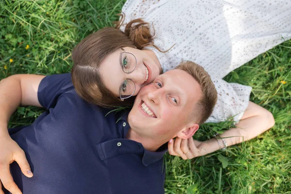 夏天男人和女人的乐趣 一对年轻夫妇在草地上躺在一起 面带微笑 甜蜜的月亮 快乐的人和彼此的关系 — 图库照片