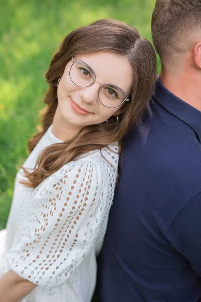 Smiling Brunette Woman Eyeglasses Sitting Back Back Unrecognizable Man Grass — Stock Photo, Image