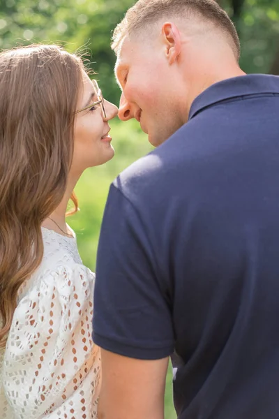 一对浪漫的年轻夫妇在绿地公园里接吻拥抱散步的侧影 有浪漫周末 生活方式和爱情的年轻人 — 图库照片