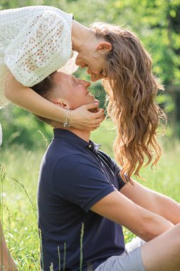 Birbirine aşık bir çift. Şefkat ve kucak, erkek ve kadın birbirlerinin gözlerinin içine bakar. Gün batımı. Yaz havası, uzun saçlar. Öpüşme