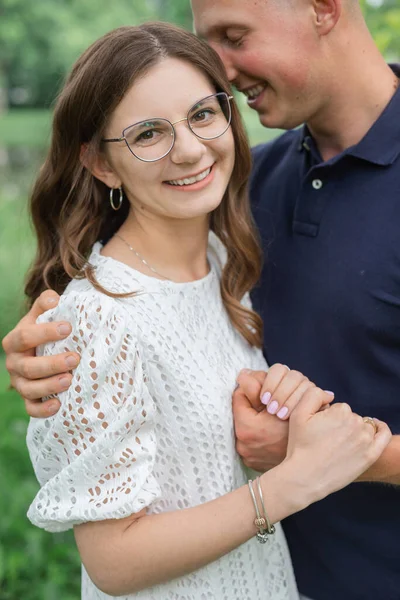 一对快乐的欧洲夫妇在公园里享受假期的浪漫照片 拥抱和快乐在一起 戴眼镜的女人和站在树间接吻的男人 — 图库照片