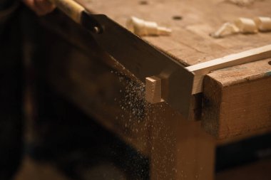 Tanımlanamayan marangoz işçisi, tezgahta kereste kesiyor ve kullanıyor. Metal çelik ahşap bağlantı aletleri. Atölyede mobilya yapmak ve tamir etmek, ahşap işçiliği