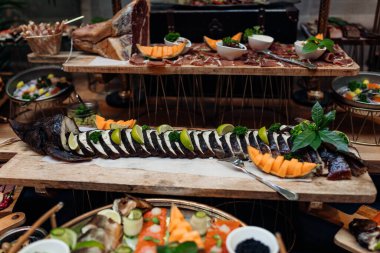 Sergi ve çeşitli balık resimleri ve tepside güzel dekorlu tütsülenmiş et sergisi. Lezzetli soğuk aperatif, besleyici yemek. Yemek salonu, lezzetli yemek, lüks servis..