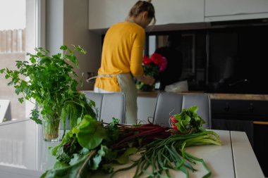 Sağlıklı taze pancar kökü sebzeleri ve hafif mutfakta masanın üzerinde yapraklar. Evde kadın yemek salatasının dikiz aynası. Yazın kilo vermek için organik ekolojik biyo-tarım kabı. Diyet detoksu