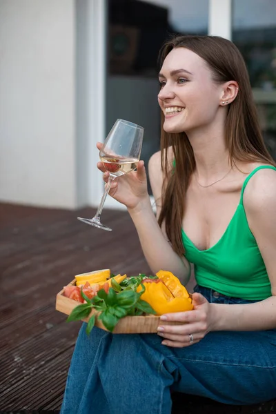 Lächelnde Frau Sitzt Auf Der Terrasse Mit Einem Glas Weißwein — Stockfoto