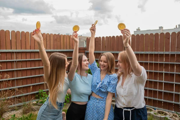 Сміються Молоді Дівчата Стоять Разом Піднімаючи Руки Апельсинами Дивлячись Один — стокове фото