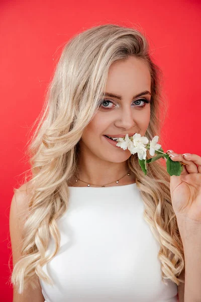 Portret Młodej Pięknej Blondynki Kwiatami Jaśminu Wargach Czerwonym Tle Patrzącej — Zdjęcie stockowe
