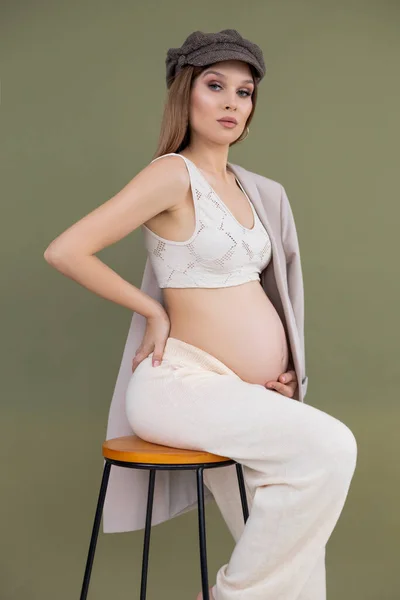 Ciężarna Szczupła Urocza Kobieta Oliwkowym Tle Ciąża Koncepcja Macierzyństwa Siedząc — Zdjęcie stockowe