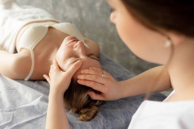 Dişi osteopat, spazmı tedavi etmek için boynunu ve başını iyileştiriyor. Manuel terapi merkezi ya da klinik. Profesyonel tedavi, alternatif tıp. Sağlık sigortası, rehabilitasyon. Yüksek açı