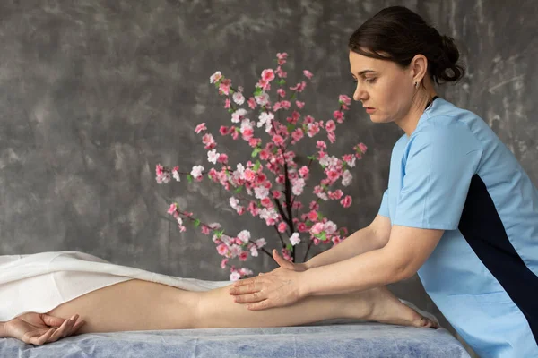 Fyzioterapeutka Provádějící Masáže Nohou Pacientek Lázeňském Salonu Proti Větvičkám Sakura — Stock fotografie