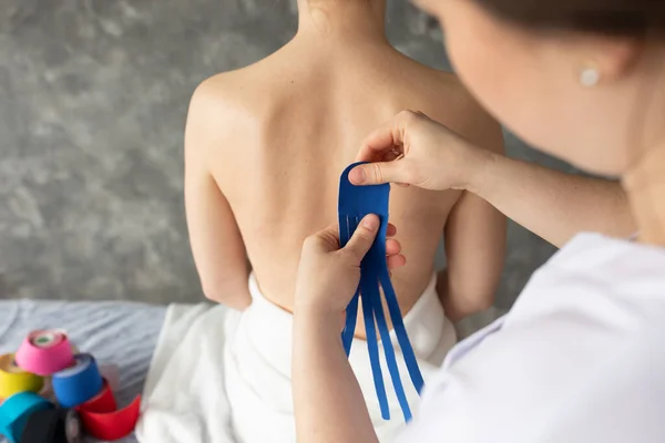 Closeup Rearview Cropped Female Physiotherapist Applying Tapes Patient Back Kinesiology — Stockfoto