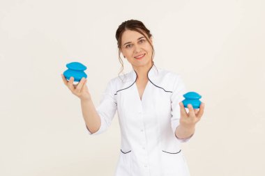 Gülümseyen, bulaşıcı kadın terapist elle vakum antiselülit masajı için mavi Çin baloncuk bardakları gösteriyor. Vücut ve cilt bakımı, kaplıca salonunda tedavi. Alternatif doğu tıbbı. Boşluğu kopyala