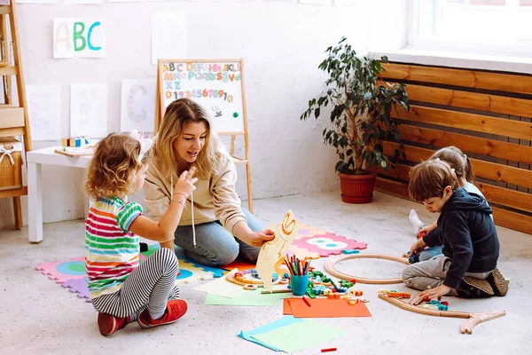 Woman Educator Showing Picture Girl Sitting Floor Kindergarten Kids Folding — Stockfoto