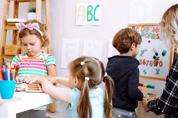 Group Cute Children Pupils Studying Help Teacher Woman Bright Classroom — Stockfoto
