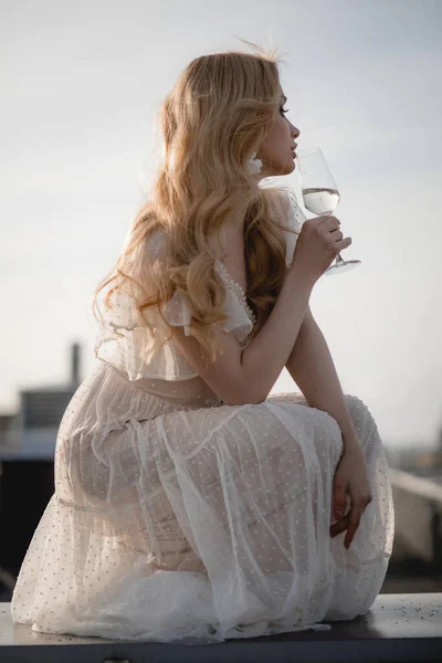 Gyönyörű Romantikus Fehér Ruha Guggolt Oldalra Egy Pohár Pezsgővel Tetőteraszon — Stock Fotó