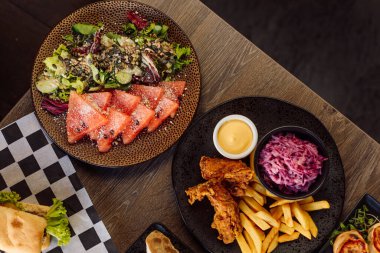 Pudra, sarımsak ve sebzeli karpuz salatası ve kızarmış ızgara tavuk, patates kızartması, pancar kökü salatası, patlıcan ve sos. Kontrol edilmiş peçeteye sandviç. Bolca yemek. Üst görünüm