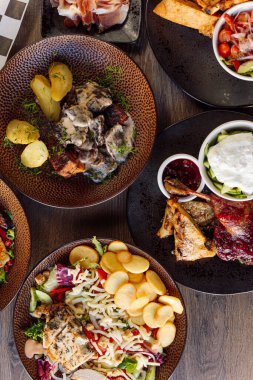 Masada dikey restoran yemeği var. Sebze ve biber, kızarmış ızgara tavuklu mantar patates, salata ve kırmızı dut, sarımsak sosu. Masa düzeni. Üst manzara, düz uzanma