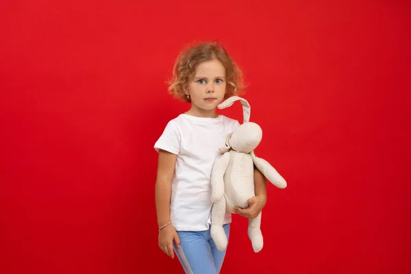 Affascinante Bambina Tenere Mano Giocattolo Preferito Farcito Sfondo Rosso Vuoto — Foto Stock
