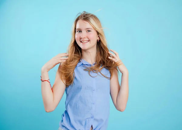 野生の髪のティーンの女の子は 空の青の背景に肩の高さで調達手で立つ スタイリッシュなノースリーブシャツの幸せな学校の子供の肖像画 10代のファッション夏の服 — ストック写真