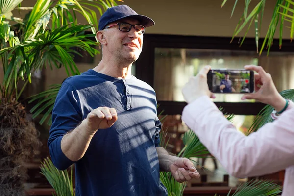 Şapkalı, gözlüklü, konuşan ve video kaydında el kol hareketi yapan olgun bir adam. Kırpılmış kadın eller, gezgin blogcuların rekor seviyede eğitim programı için akıllı telefonu tutuyor. Günlükler, çevrimiçi yayınlanan hikayeler