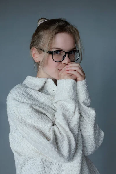 黒い眼鏡の若い女性は 灰色の背景 無料のコピースペースに手を置くことによって暖かくなります 居心地の良い白いセーター 寒い天候のためのシャツ カジュアルな季節の服 女性の基本的な服 — ストック写真