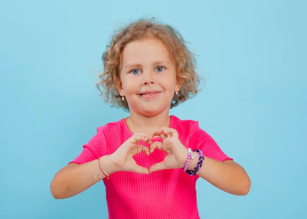 Güzel Küçük Kız Kalbi Parmaklarıyla Şekillendirir Aşkı Boş Mavi Arka — Stok fotoğraf