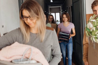 Yeni kampüs yatakhanesine taşınan gülümseyen öğrenciler, ellerinde karton kutularla yeni bir daire. Üniversitede ya da üniversitede bağımsız bir hayata hazır olarak eğitim başlar. Yeni daireye taşınma ve taşınma