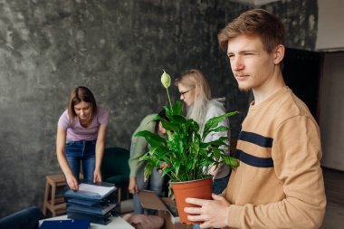Yoğunlaşmış, ciddi, düşünceli öğrenciler gri oturma odasında bavullarını hazırlıyorlar. Daireni değiştir ve yaşamak için yeni bir yer bul. Kampüste yaşayan birinci sınıf öğrencileri için ekonomi ve finans