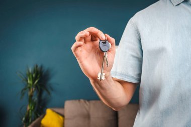 man holds a house key in his hand. the key to the new house. new housing concept