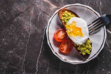 hot poached egg on toast with avocado. poached egg for breakfast. breakfast vegetarian toast with avocado and egg. vegan food