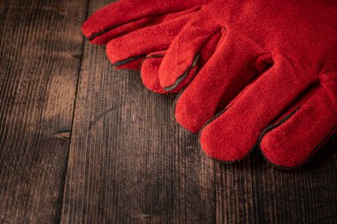 red welder gloves on a wooden background. worker's equipment