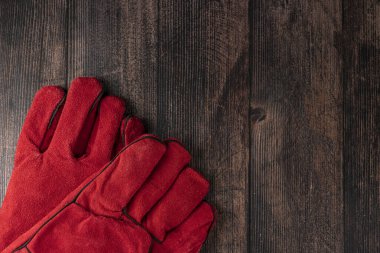 red welder gloves on a wooden background. worker's equipment