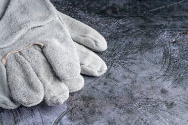 grey welder's gloves on a concrete background. the equipment of the worker. carpenter's tools