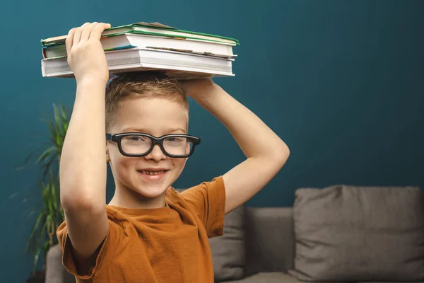 教科書を手に眼鏡をかけた少年です 少年は1年生です 眼鏡やノートを持った生徒が学校に通っています — ストック写真