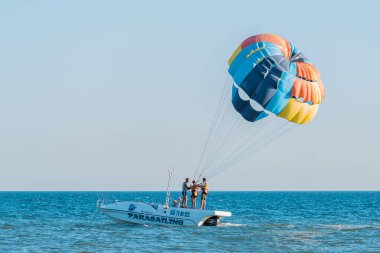 Ukrayna, Demir Liman - 31 Ağustos 2020: Ekstrem sporlar ve heyecan verici dinlenme aktiviteleri. Denizdeki bir motorlu teknede bir insan paraşütle gezici bir turist başlatacak..