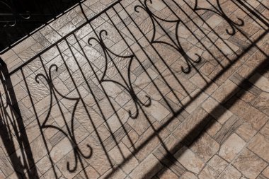 Mimari siyah gölge deseni ve şehrin dışındaki fayanslarda güneş ışığı siluetleri..