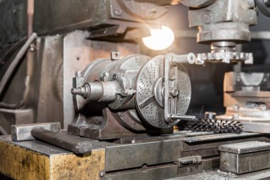 Endüstriyel bir işletmenin atölyesinde yakın çekim ekipmanlarıyla çalışan eski bir değirmen makinesi..