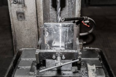 Bir endüstriyel fabrikanın atölyesinde suyu soğutmak için bir tüp ile sondaj demiri delme mekanizmalarıyla metal işçiliği için işlem ve sistem, ekipman ve araç.