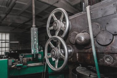 Endüstriyel fabrikanın atölyesinde metal işleme aletleri ve ekipmanlardan oluşan eski değirmen makinesinin demir yuvarlak kulpları.