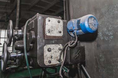 Sanayi fabrikasının atölyesindeki eski bir değirmen makinesinin kanatlı elektrikli motoru..