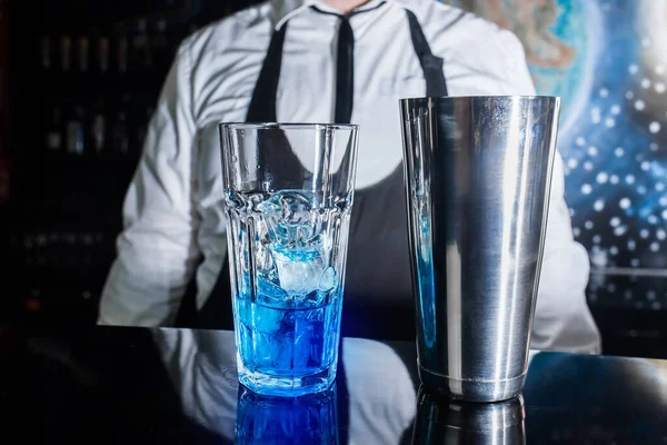 과푸른 시럽이 유리잔 이전문 바텐더의 배경에 대항하여 알코올 중독자의 칵테일을 — 스톡 사진