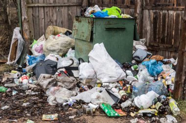 Atık cam, plastik şişe ve torbalar çöplerle dolu bir konteynerin tankında..