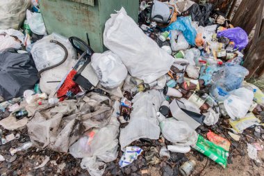 Atık cam, plastik şişe ve torbalar çöplerle dolu bir konteynerin tankında..