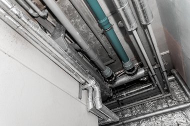 Bir sanayi fabrikasının tavanında termal yalıtım malzemesi boru boru hattındaki havalandırma havalandırma sistemi..