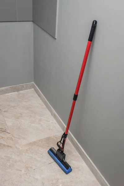 Mop stands against the wall and floor cleaning of production facilities. Household chores and hygiene of sanitary facilities.